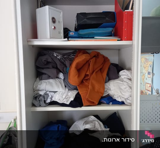 ארון בגדים עם בגדים מקופלים ומסודרים